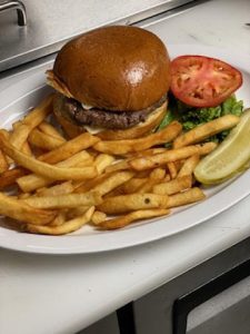 A burger and french fries on a plate.