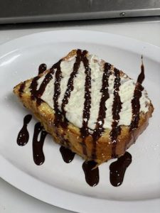 A plate of french toast with chocolate sauce on it.